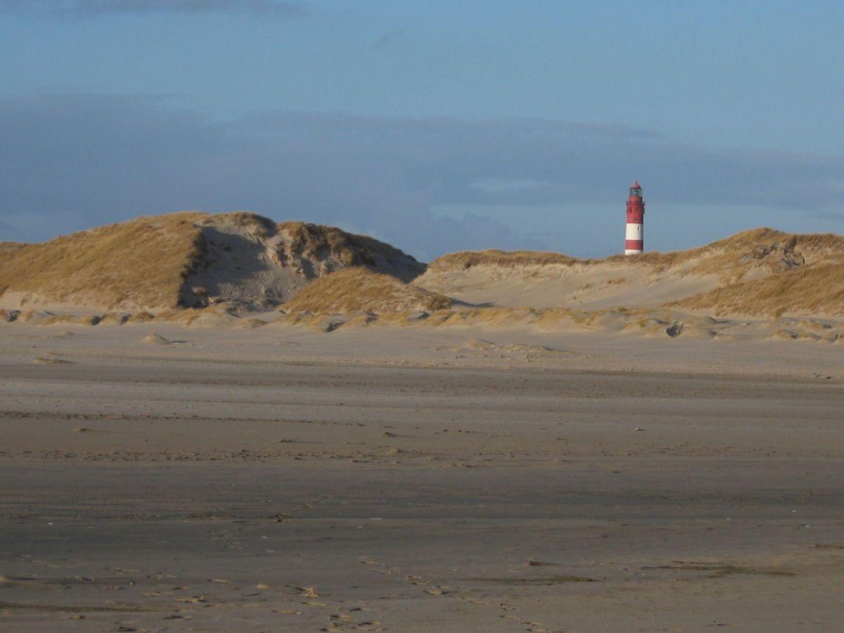 Roter Leuchtturm auf Dünen am Strand