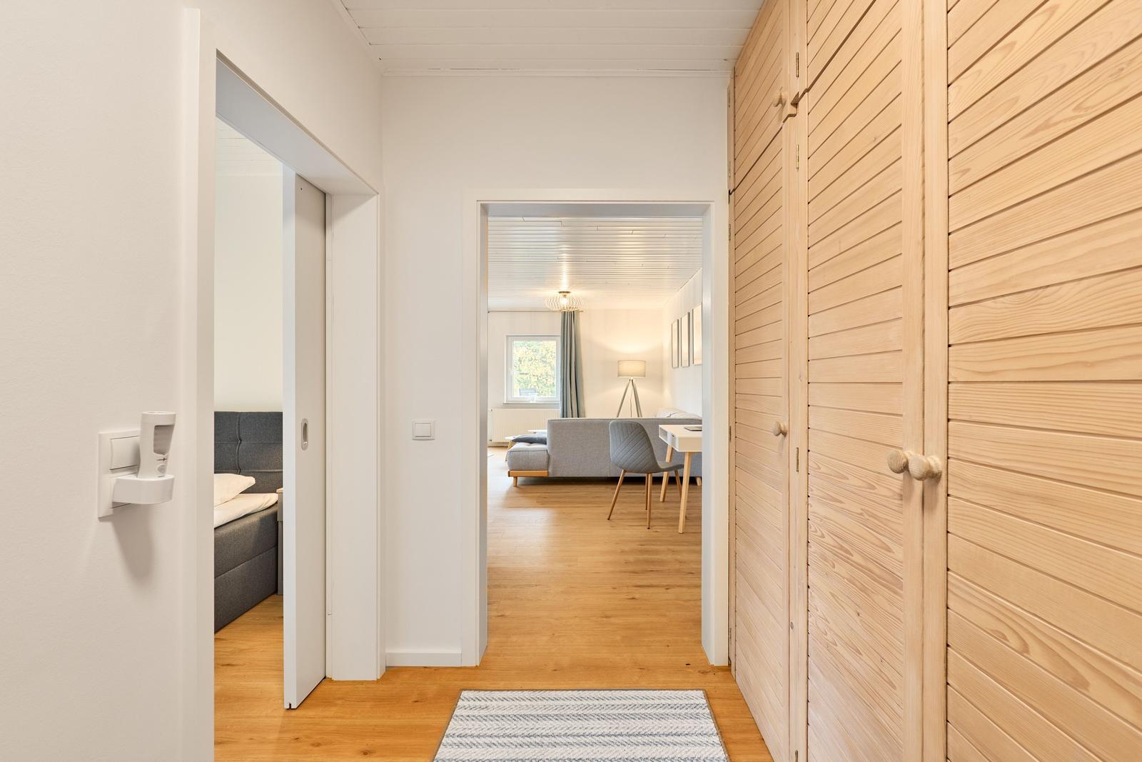 Flur mit Holzwand und Blick in Wohn- und Schlafzimmer