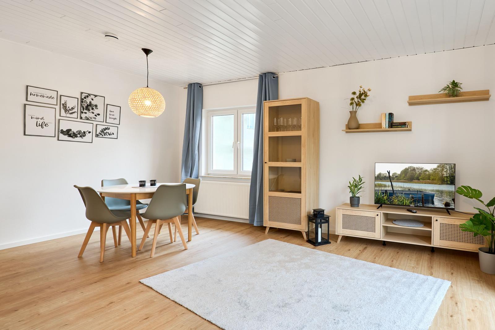 Wohn- und Essbereich mit Holzmöbeln, Fernseher und Wanddekoration.
