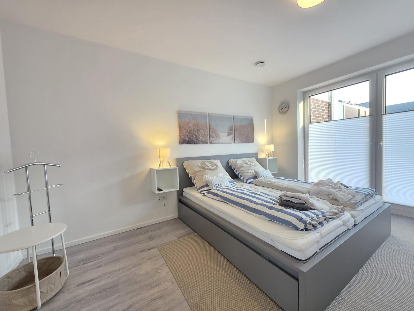 Schlafzimmer mit Doppelbett, Nachttischen und Fenster.