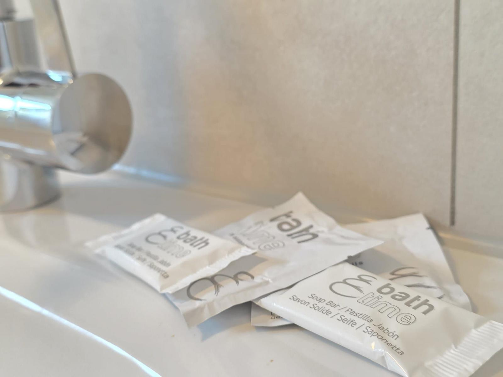 Duschkopf und Seifenverpackungen auf Waschtisch