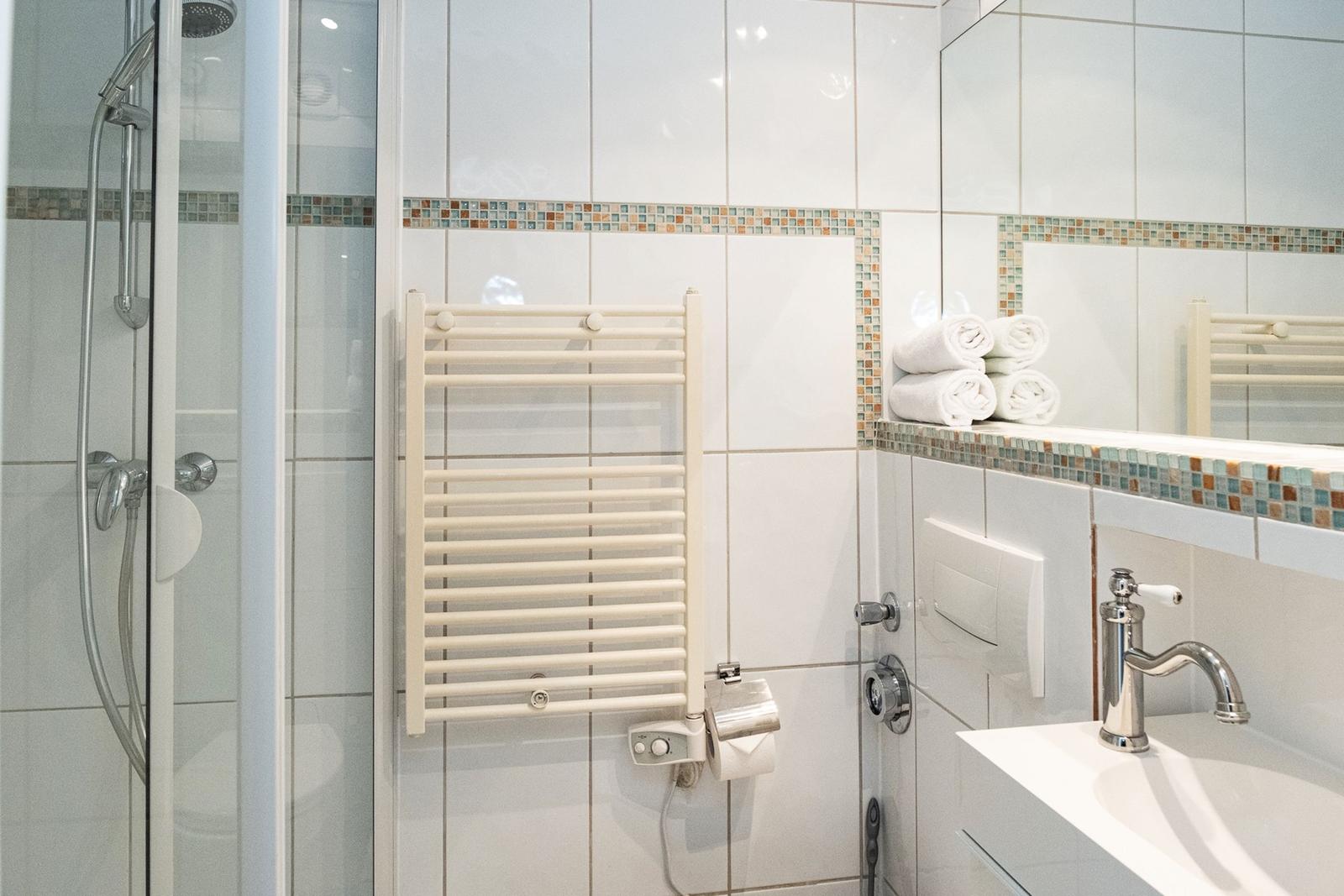 Bathroom with shower, towel rack, and sink