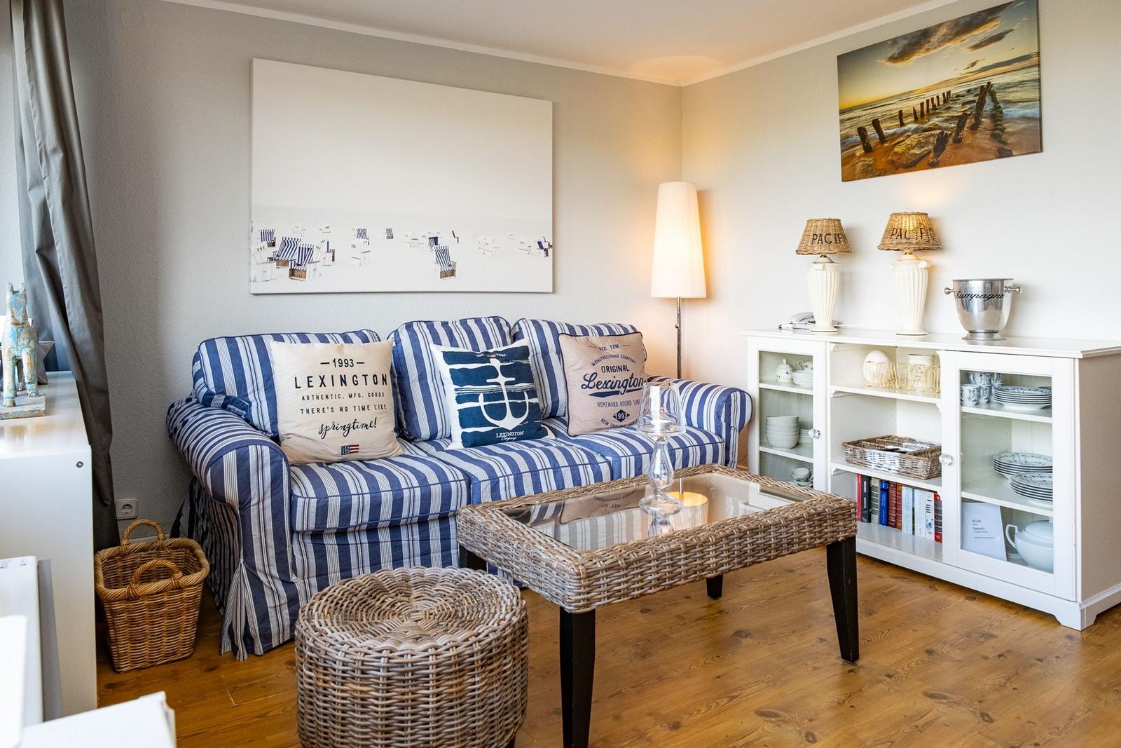 Living room with sofa, coffee table, and cabinet. Wall art and lighting visible.