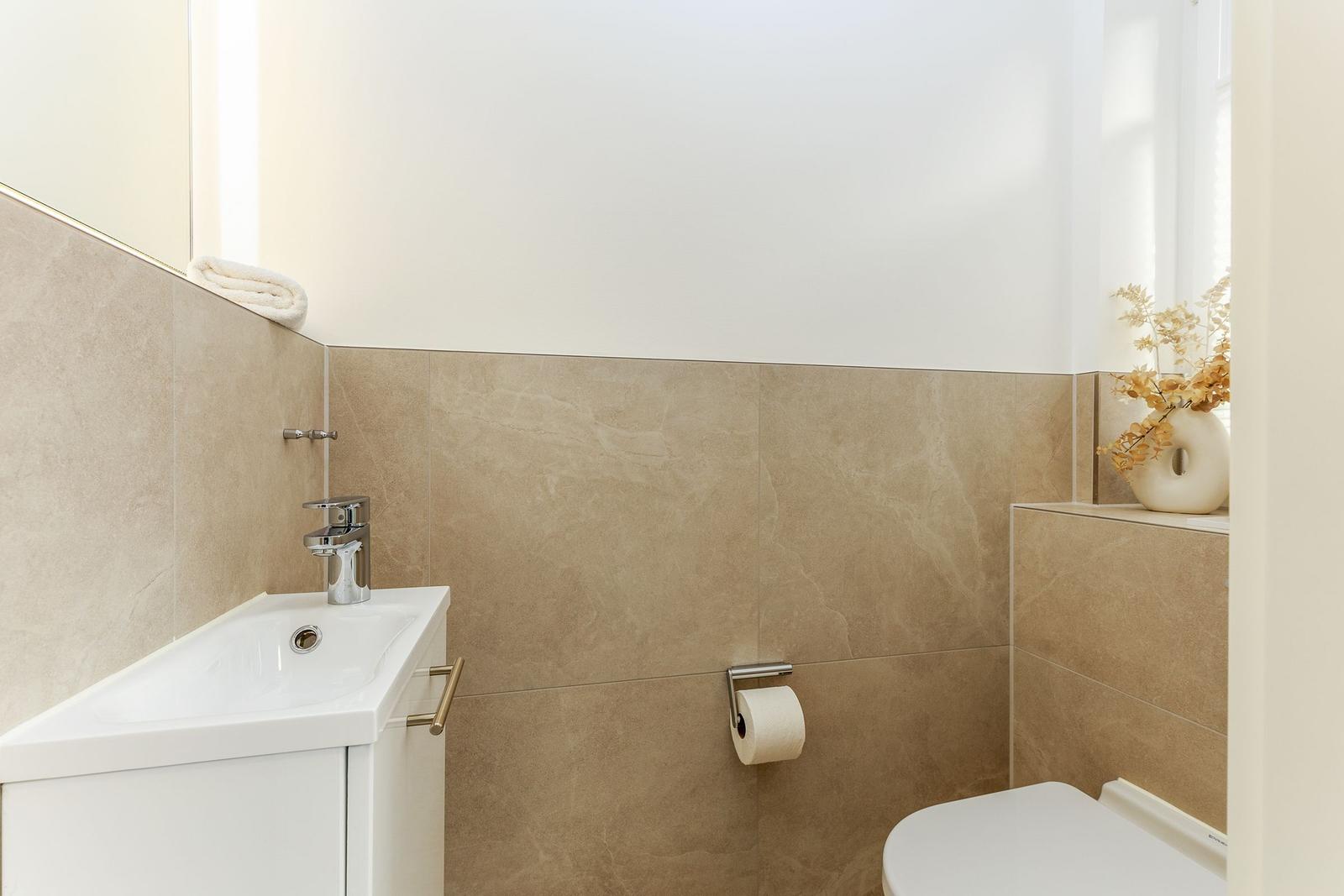 Badezimmer mit Waschbecken, Toilette und Spiegelschrank