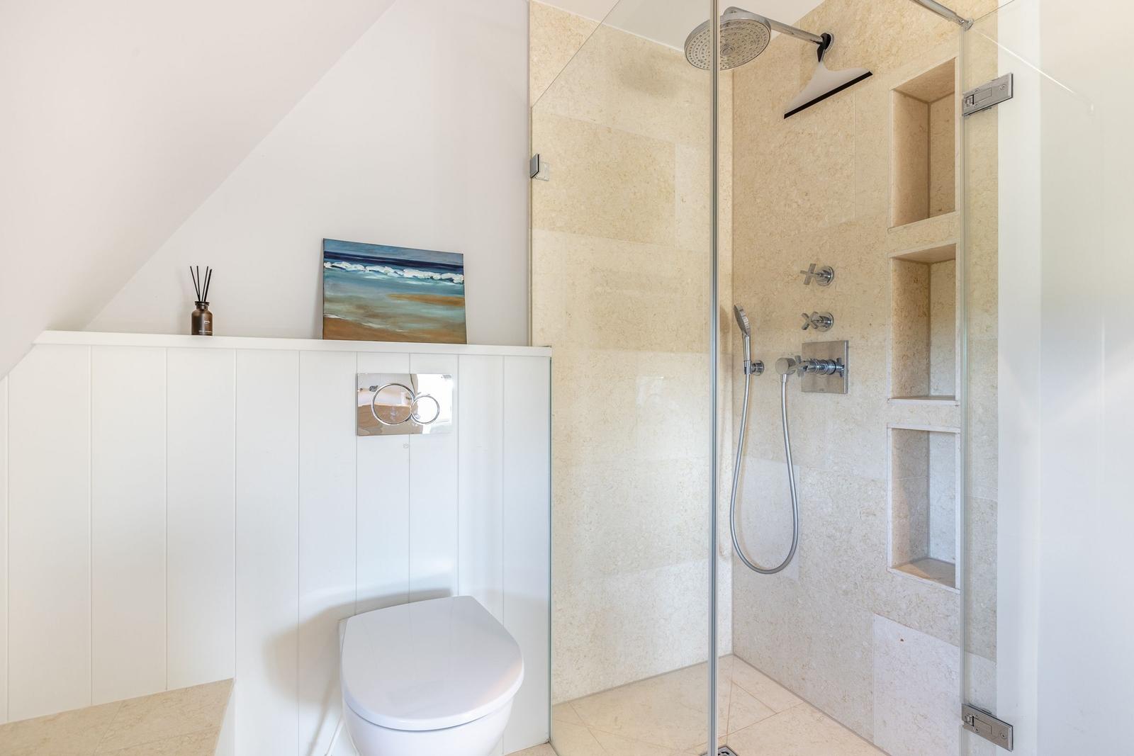 Dusche mit Glaswand, Toilette und Wandbild