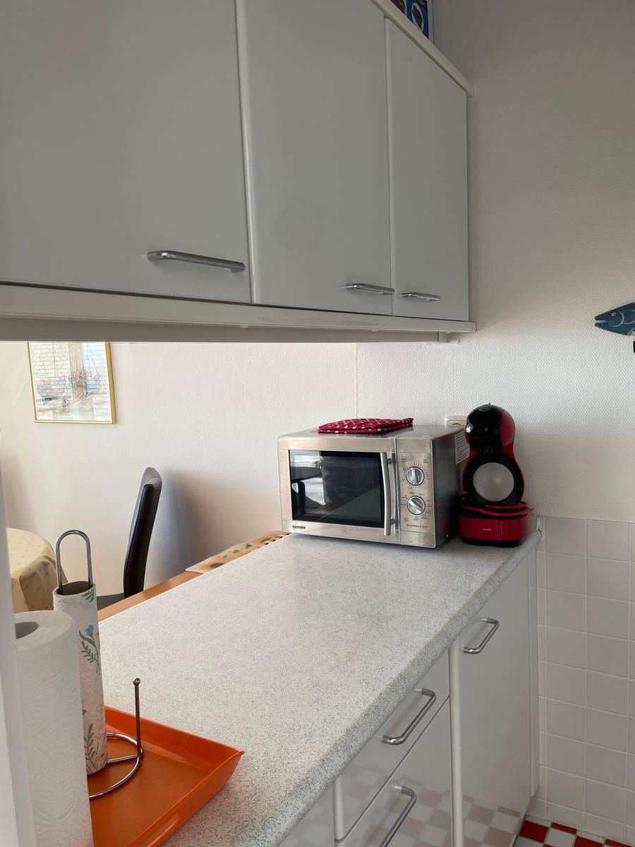 Küche mit Mikrowelle, Kaffeemaschine und Arbeitsfläche.