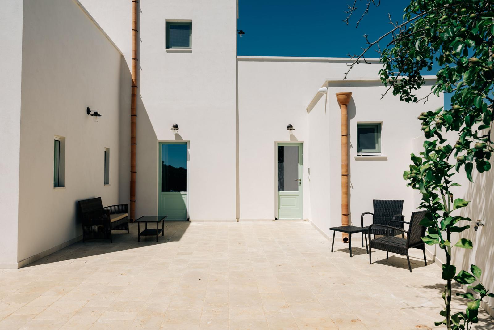 Bright terrace with seating and white walls.