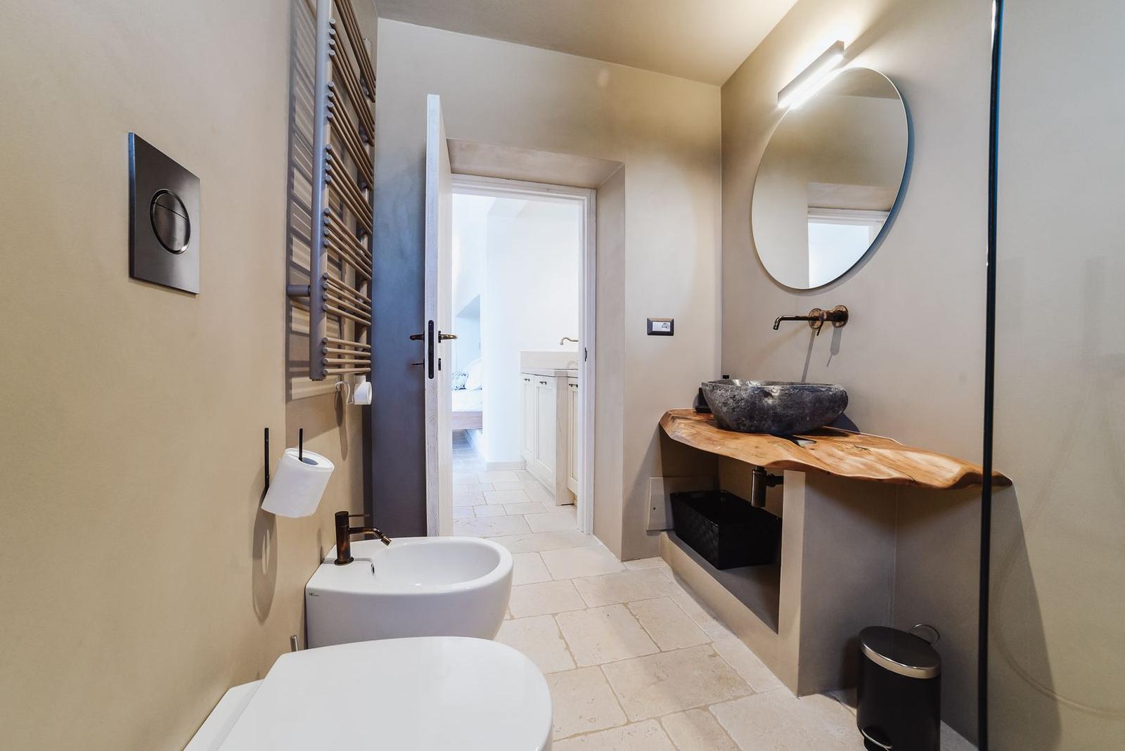 Bathroom with toilet, bidet, sink, and shower