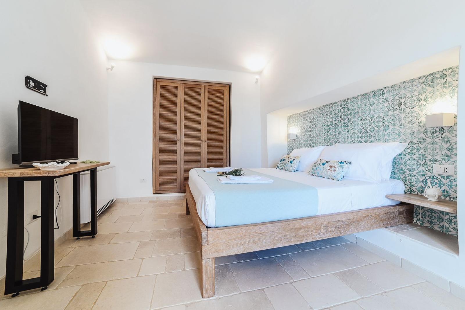 Bedroom with wooden bed, TV and wooden closets.