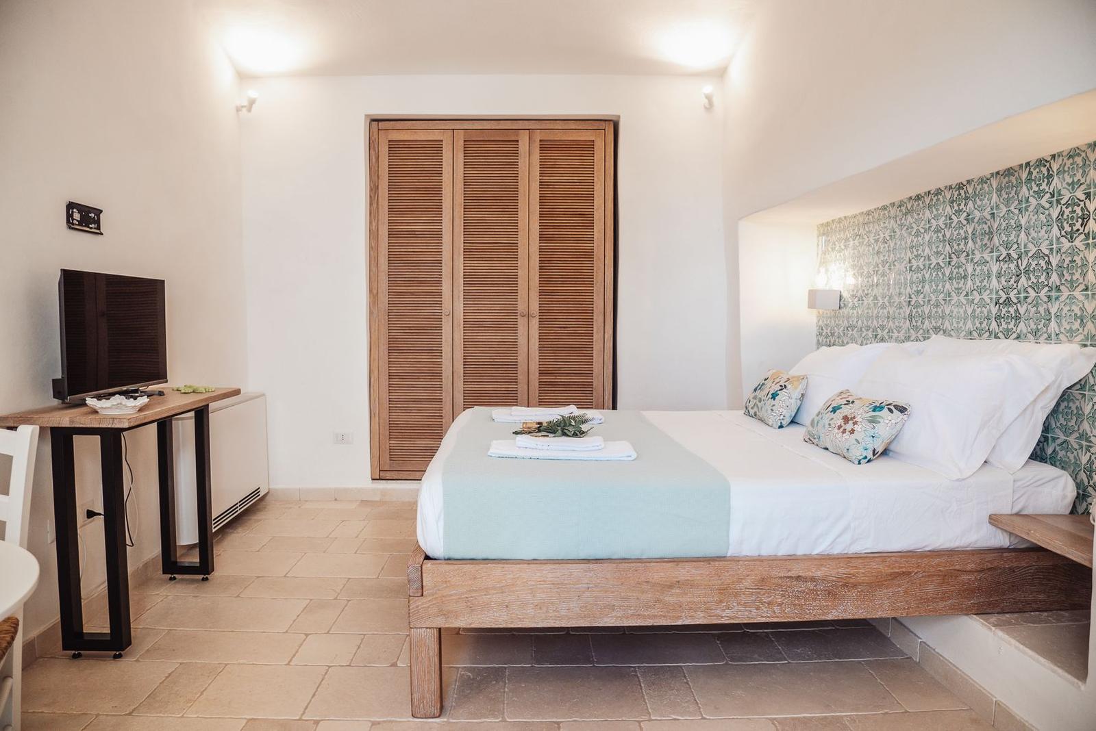 Bedroom with bed, wardrobe, and TV stand.