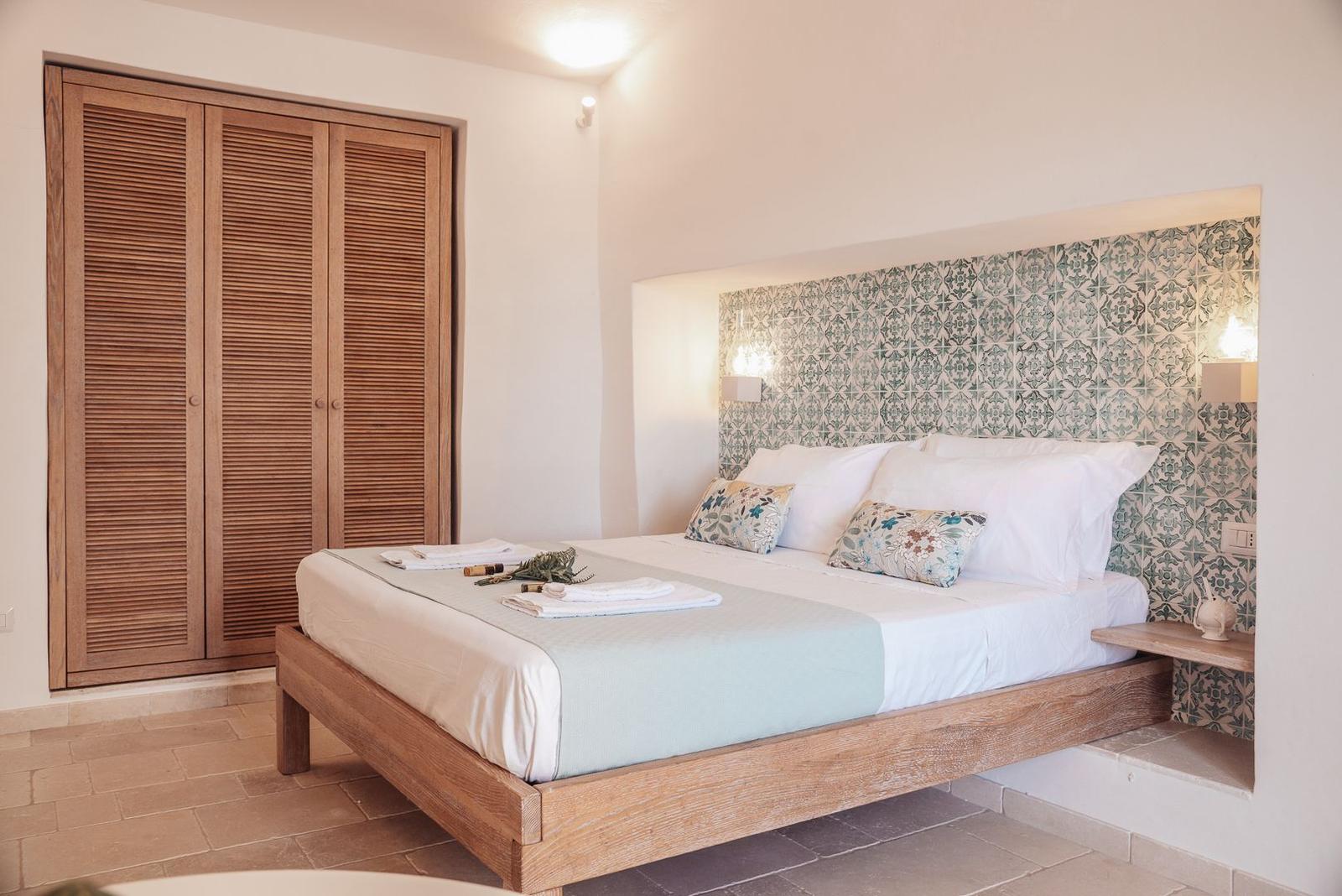 Bedroom with wooden bed, wooden closet, and patterned headboard.