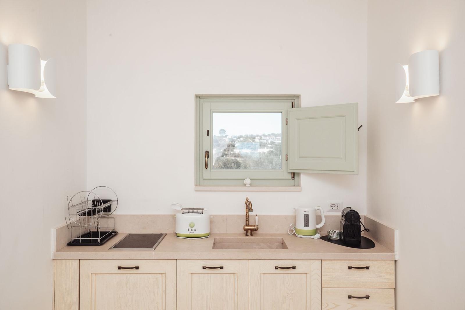 Küche mit Arbeitsplatte, Spüle, Fenster und Küchengeräten.