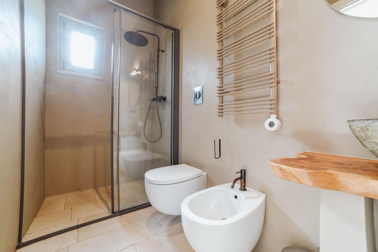 Badezimmer mit Dusche, Toilette und Waschbecken.