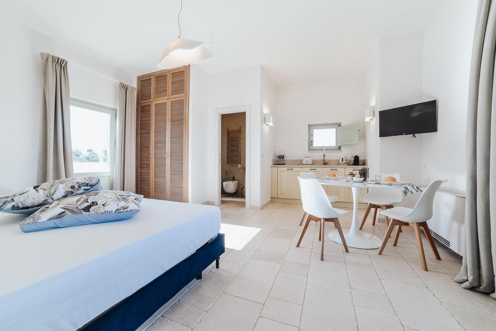 Schlafzimmer mit Bett, Schlafzimmer und Essbereich mit Tisch und Stühlen.