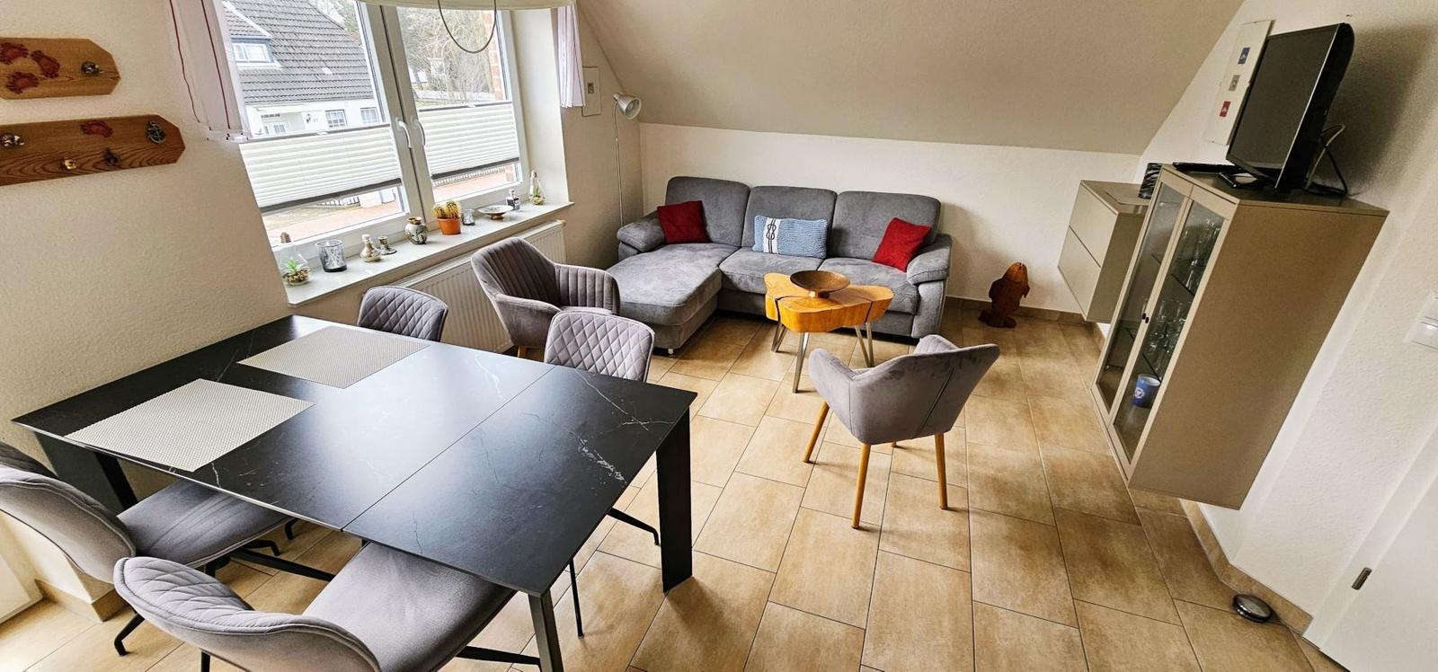 Wohn- und Essbereich mit Sofa, Esstisch und TV.