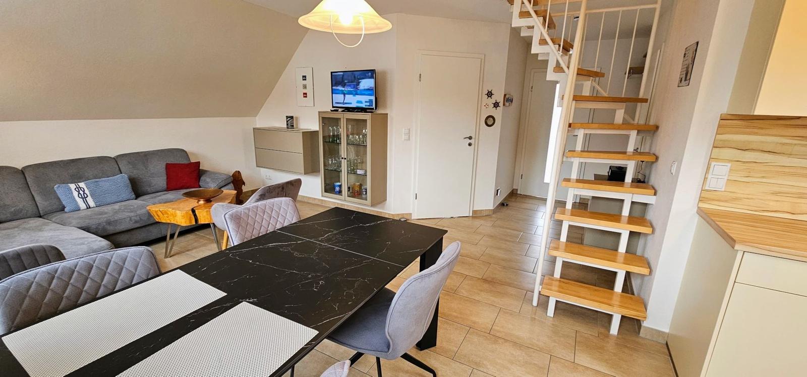 Wohn- und Essbereich mit Treppe und Fernseher