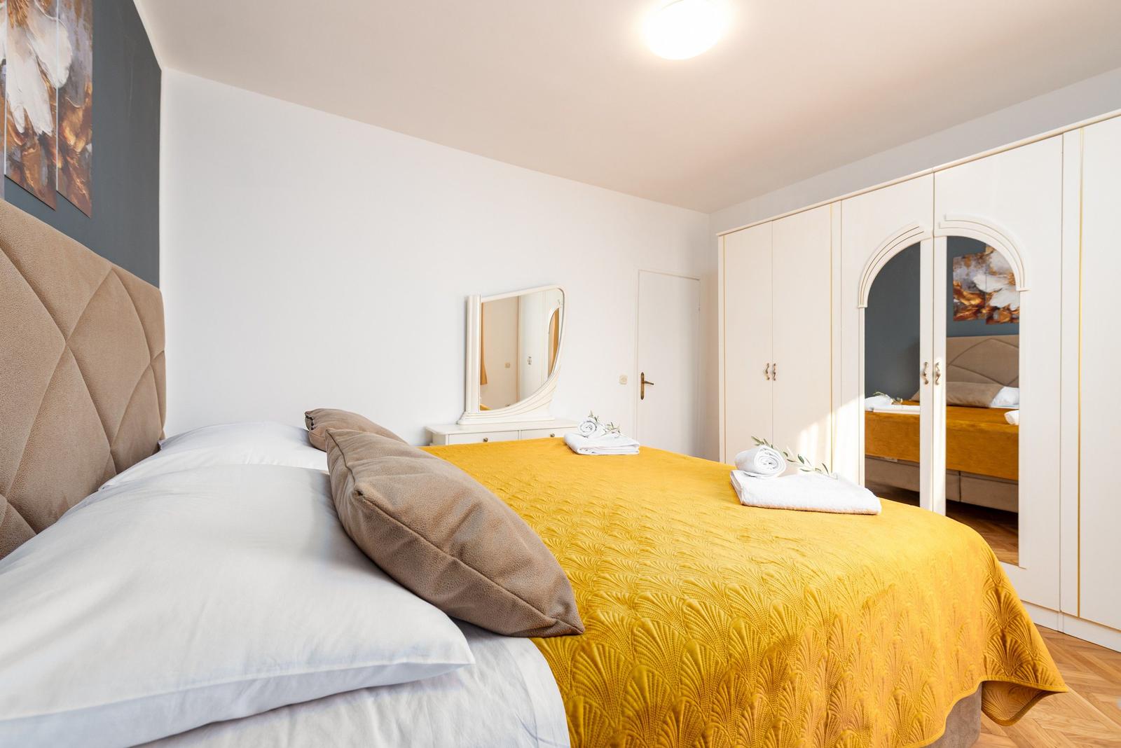 Schlafzimmer mit Bett, Kleiderschrank und Spiegel