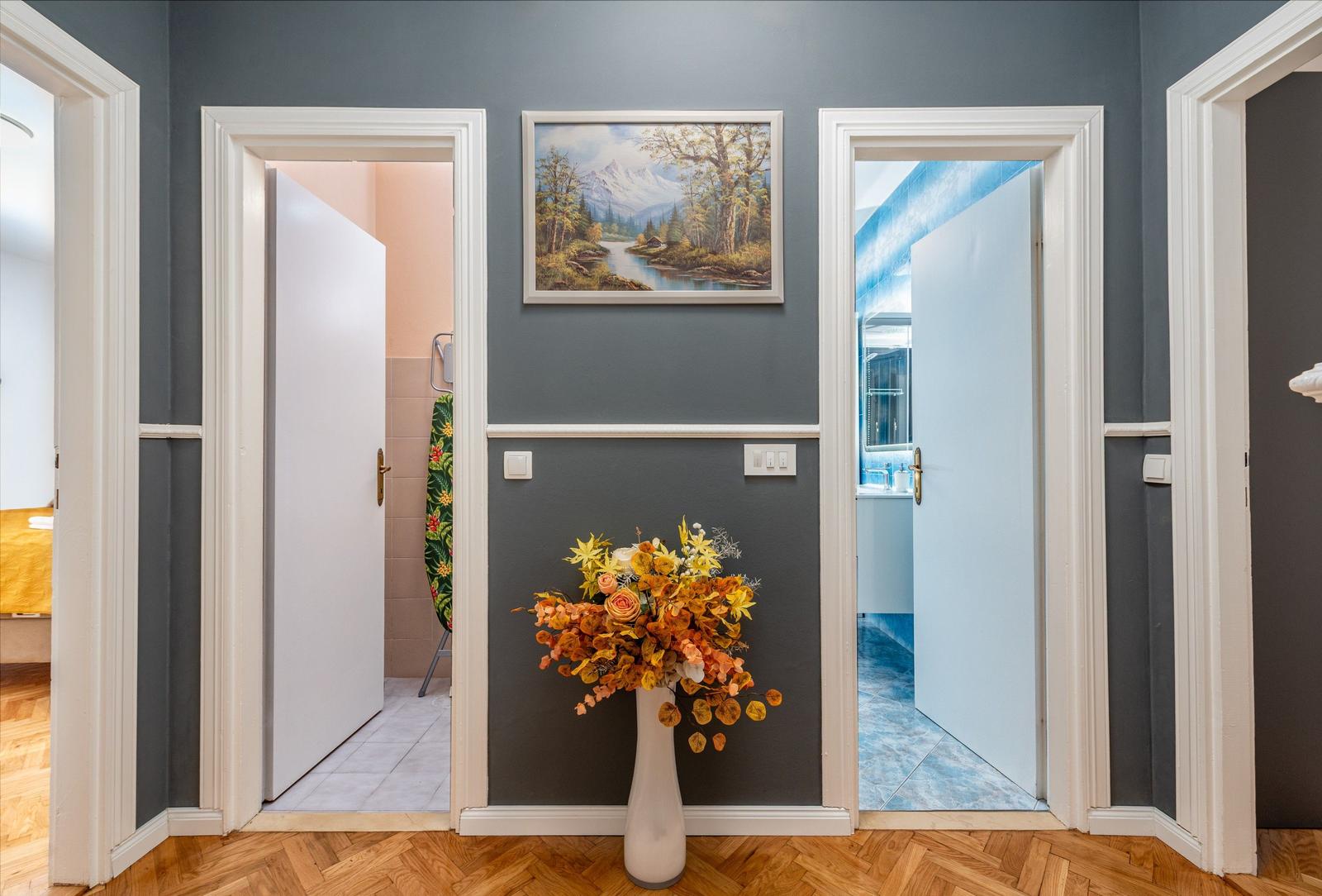 Halle mit Blumen, Bild und Türen zu Bad und Schlafzimmer