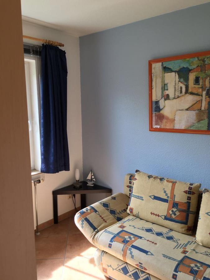 Ein Wohnzimmer mit Sofa, Wandbild und Fenster mit Vorhang.