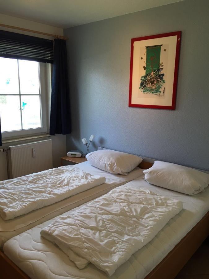Schlafzimmer mit Doppelbett, Fenster und Wandbild.