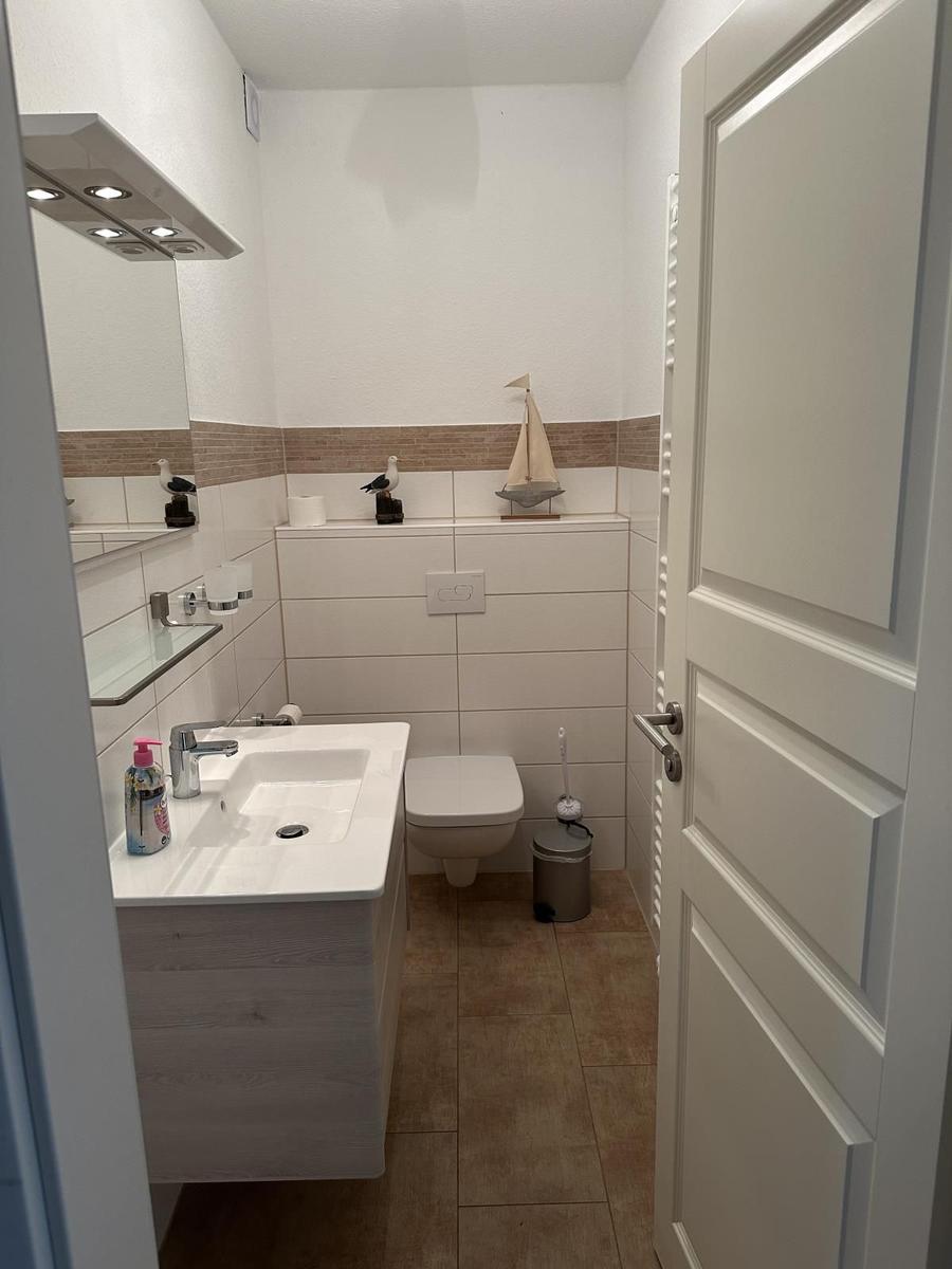 Badezimmer mit Waschbecken, Toilette und Spiegel