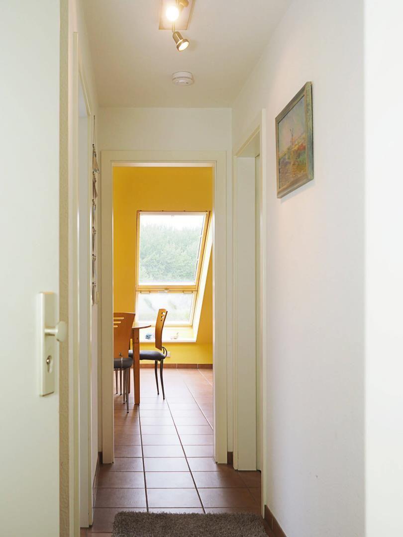 Flur mit Blick in Esszimmer mit Dachfenster und gelber Wand