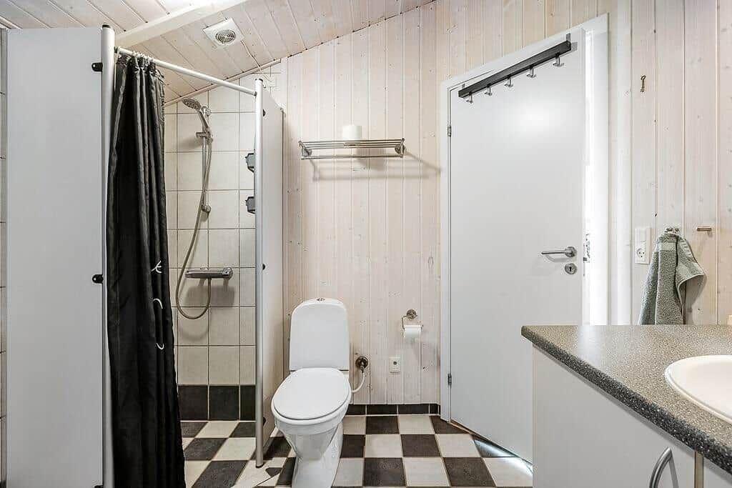 Bathroom with shower, toilet, and sink.