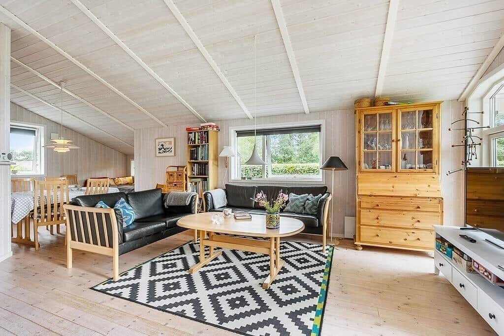 Living and dining area with wooden furniture and large window.
