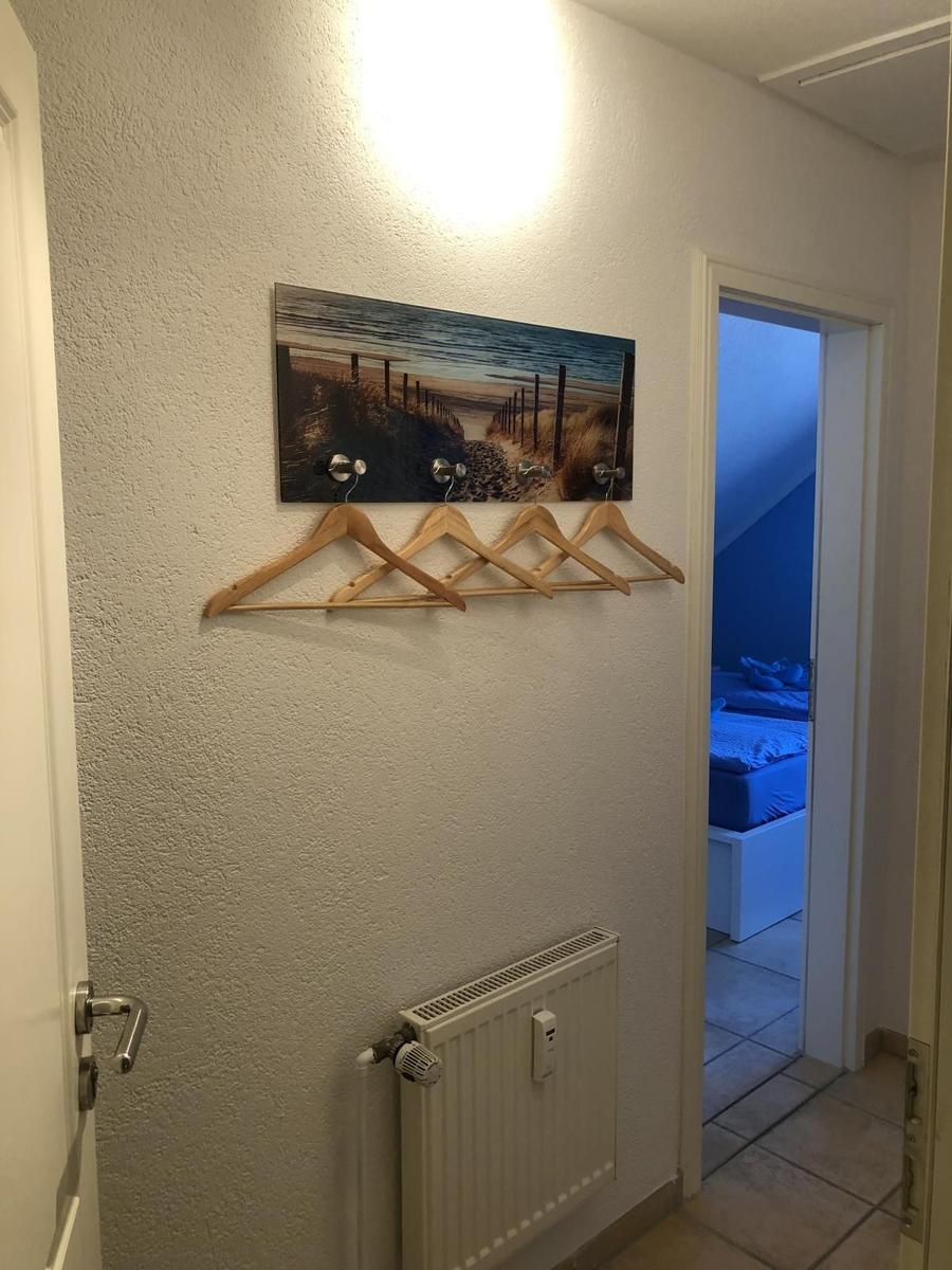 Flur mit Kleiderhaken und Wandbild, Tür zum Schlafzimmer