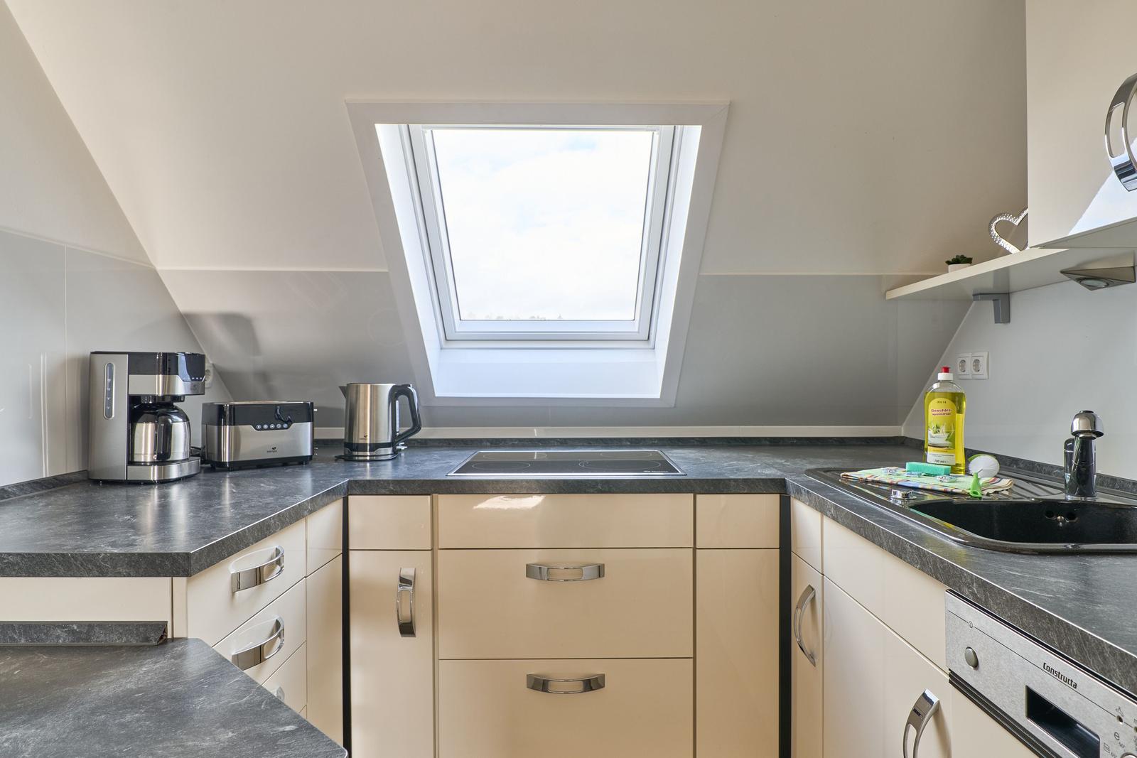 Küche mit Dachfenster, Arbeitsplatte und Spüle