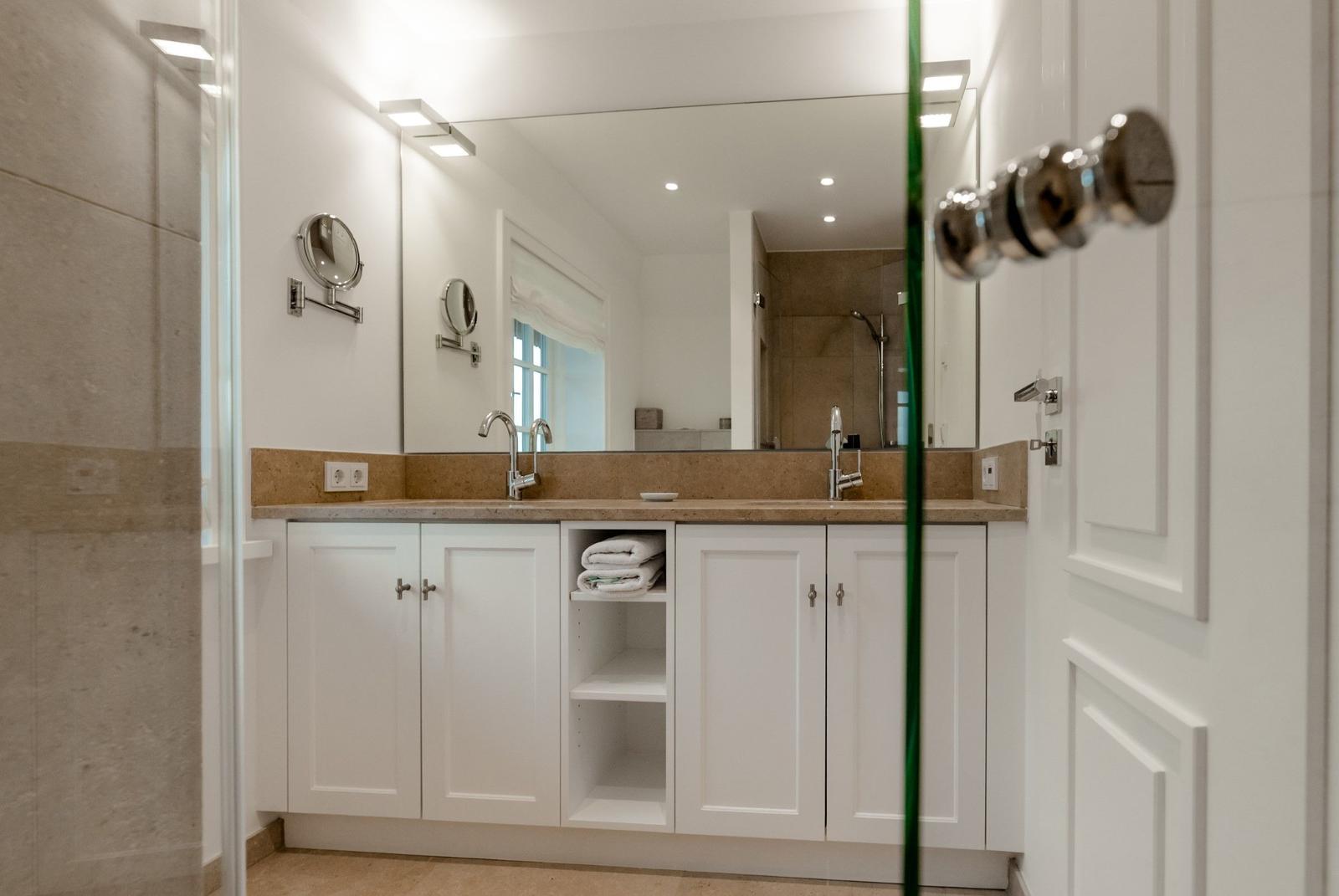 Badezimmer mit Waschbecken, Spiegel und Dusche