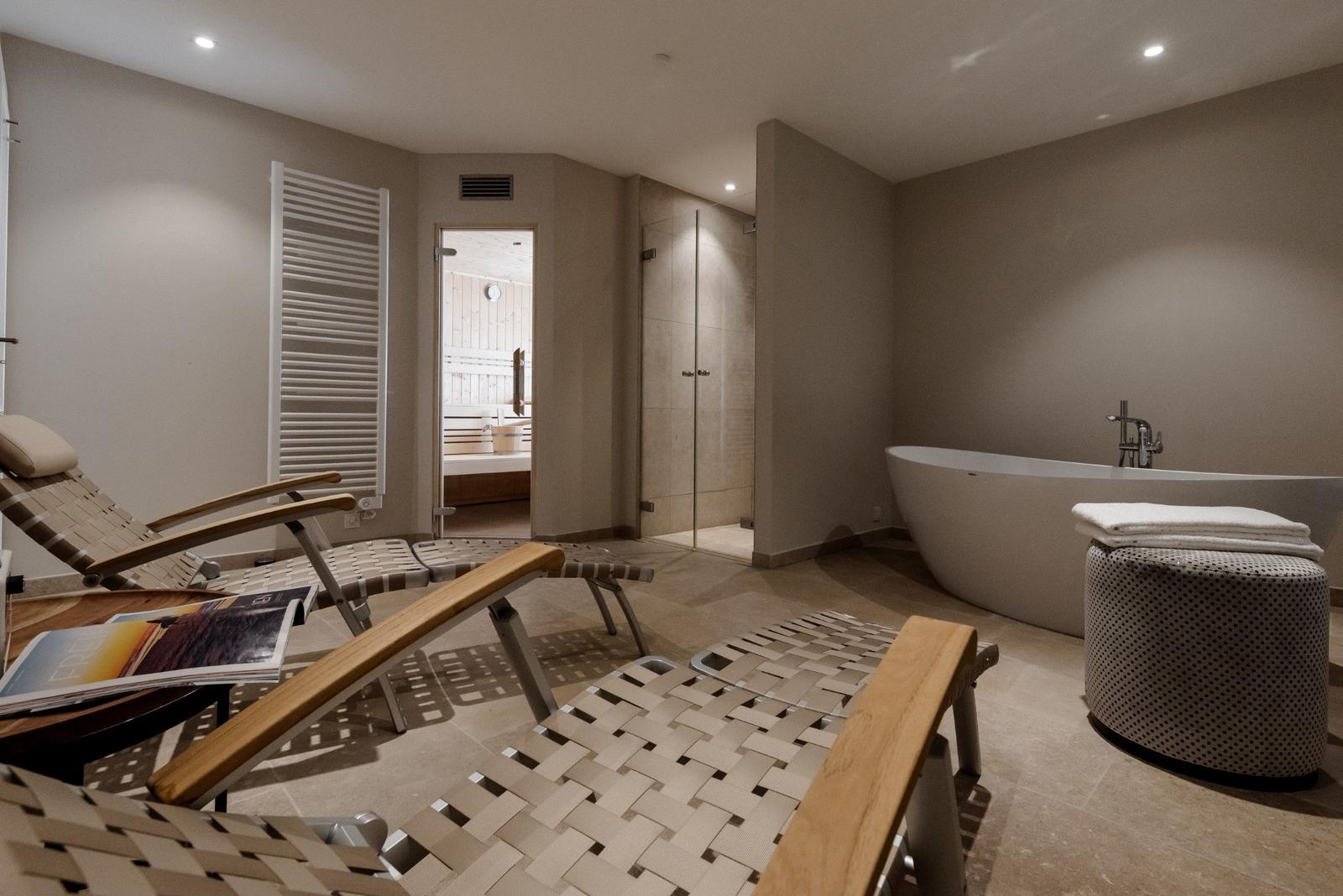 Bad mit freistehender Badewanne, Dusche und Sauna.