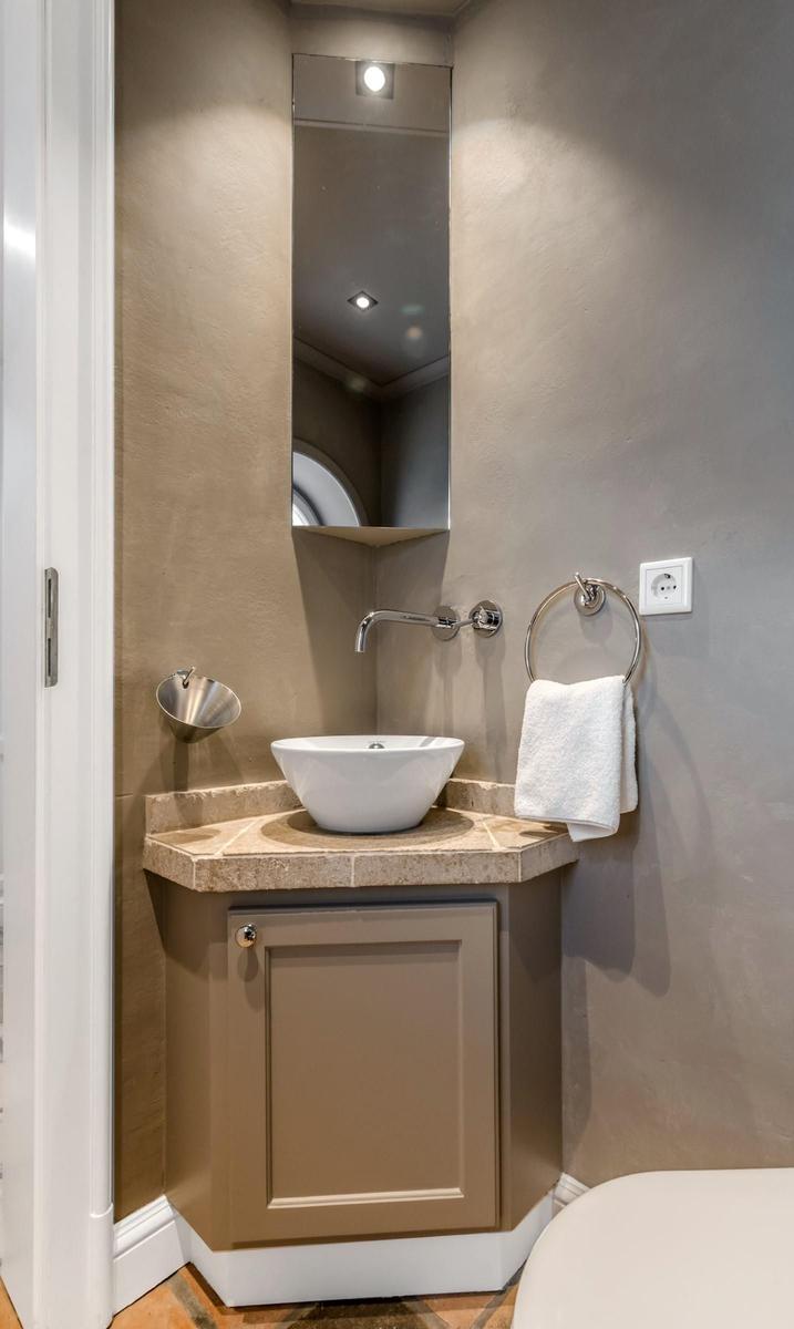 Waschbecken mit Spiegelschrank und Handtuchhalter in Badezimmer