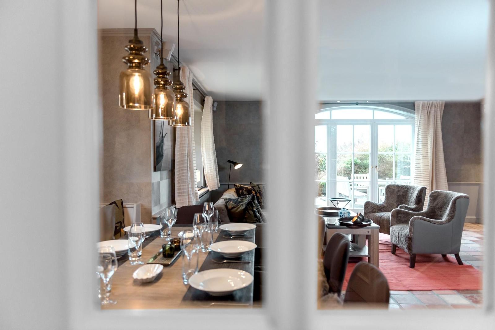 Essbereich mit Tisch und Stühlen. Wohnbereich mit Sitzgelegenheiten und Fenster.