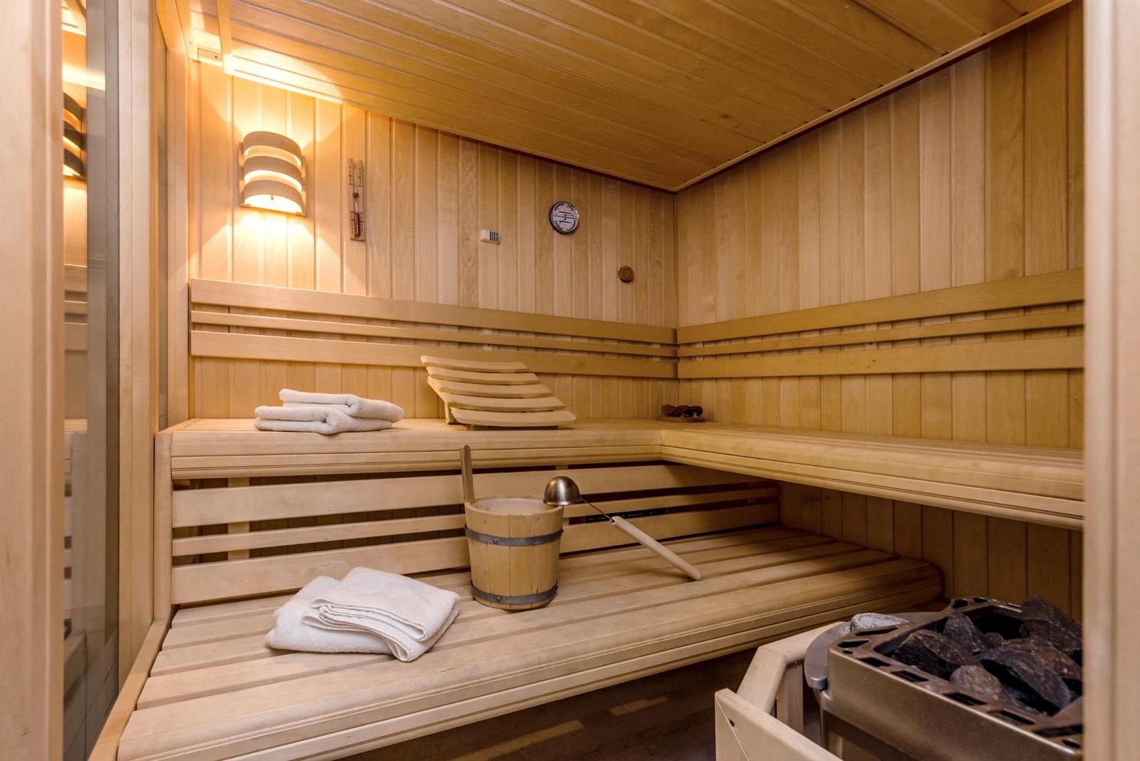 Sauna mit Holzbank, Handtuch und Eimer