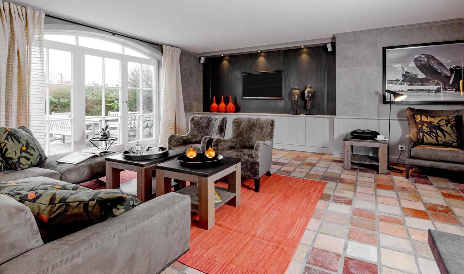 Wohnzimmer mit Sitzgruppe, Flachbildschirm und Terrassentür.