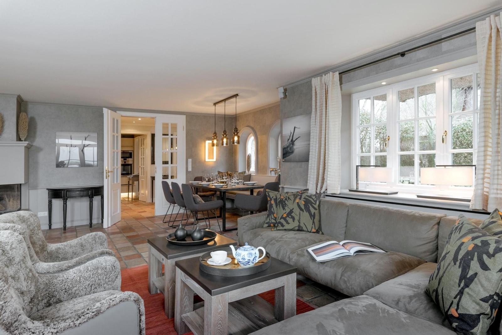 Wohn- und Essbereich mit Sofa, Tisch und Blick auf Garten.