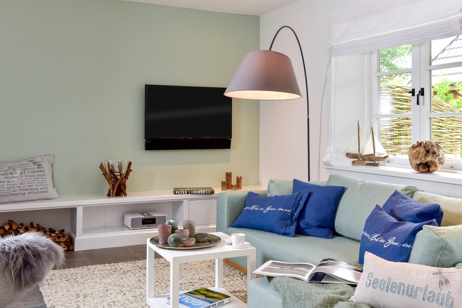 Wohnzimmer mit Sofa, Fernseher und Fenster mit Blick.