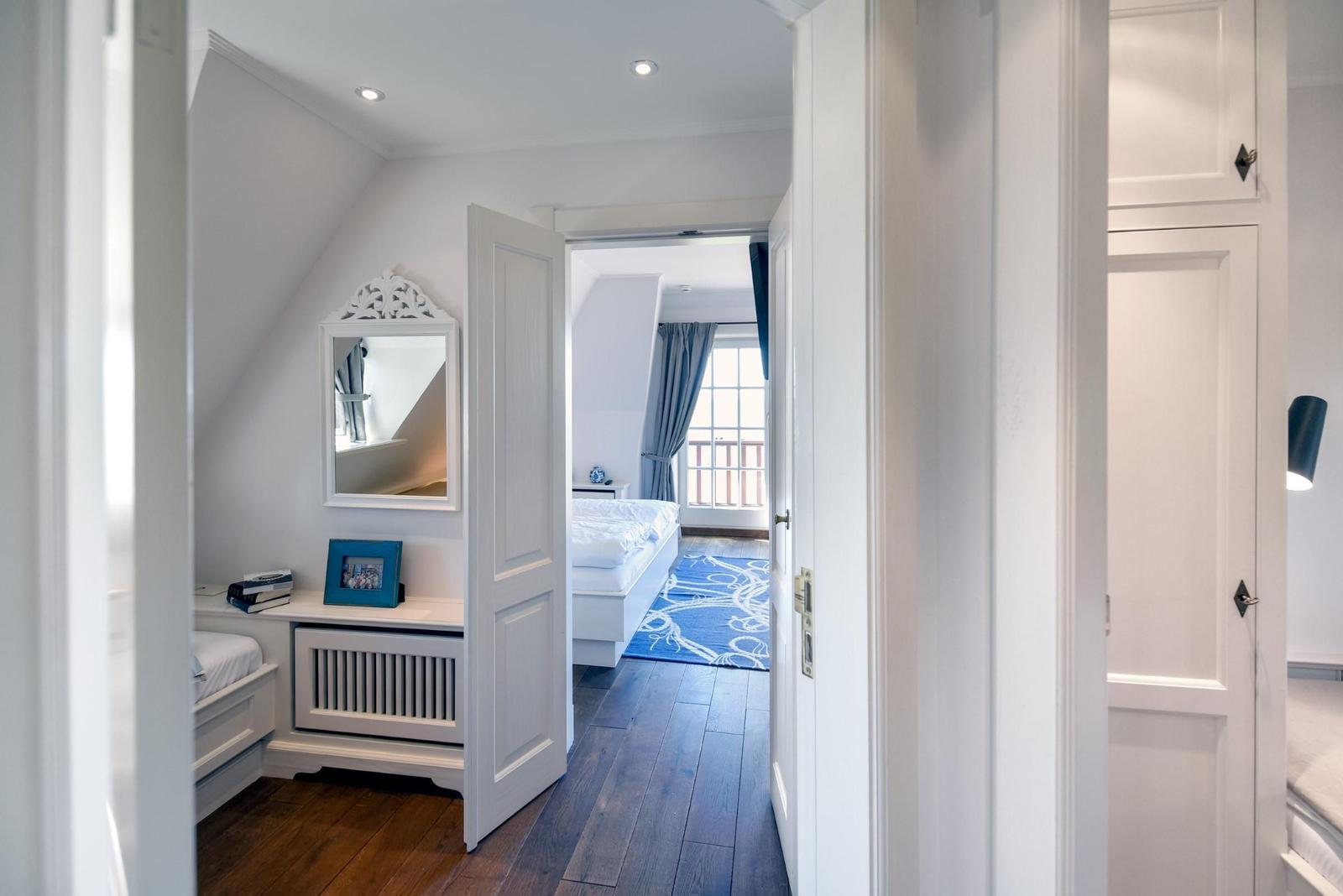 Durchgang zu Schlafzimmer mit blauem Teppich und Fenster