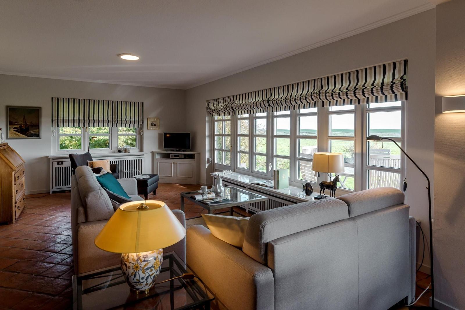 Living room with sofa, coffee table, and windows to the garden