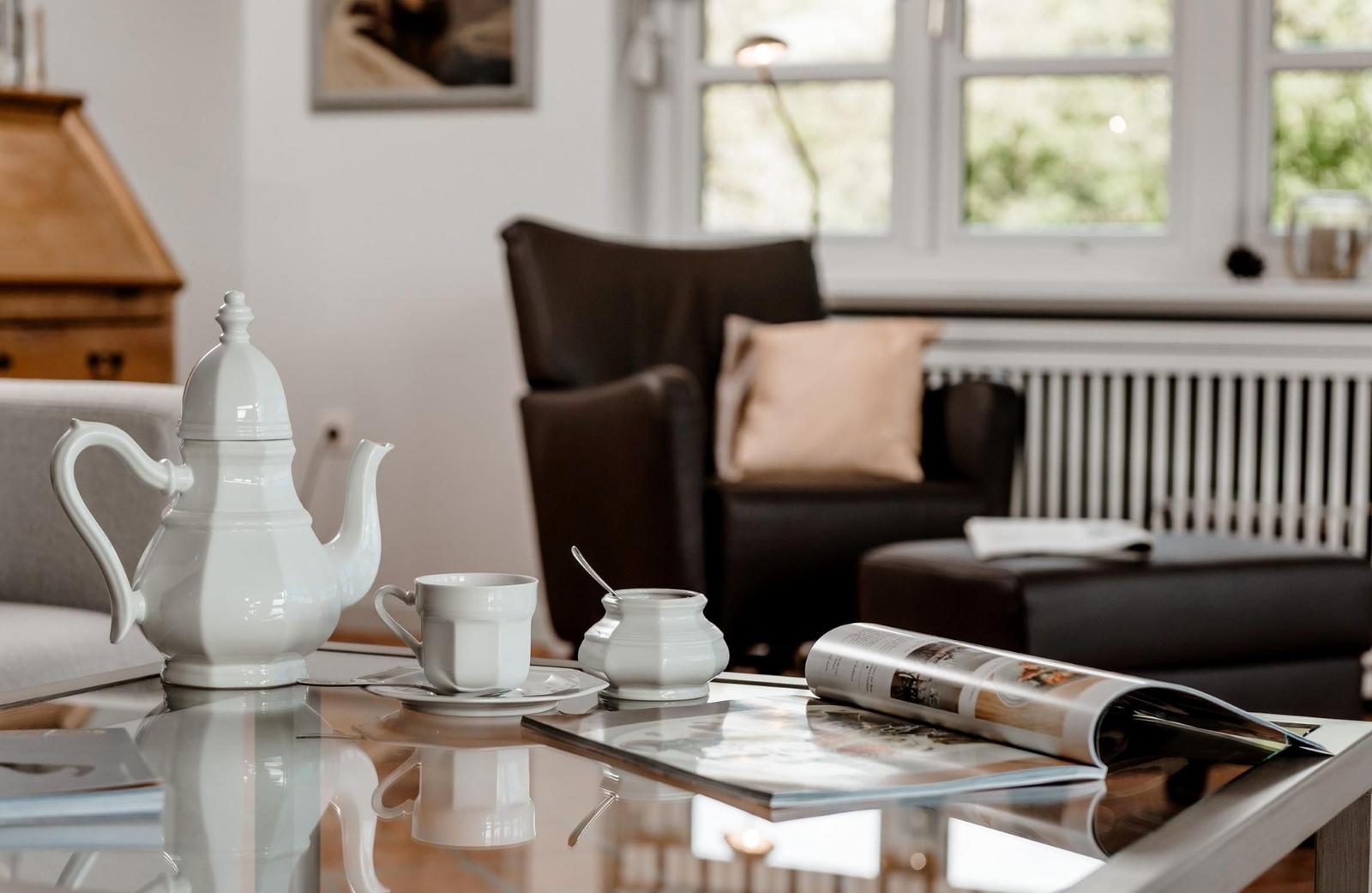 A living room with table, coffee cup, and magazine.