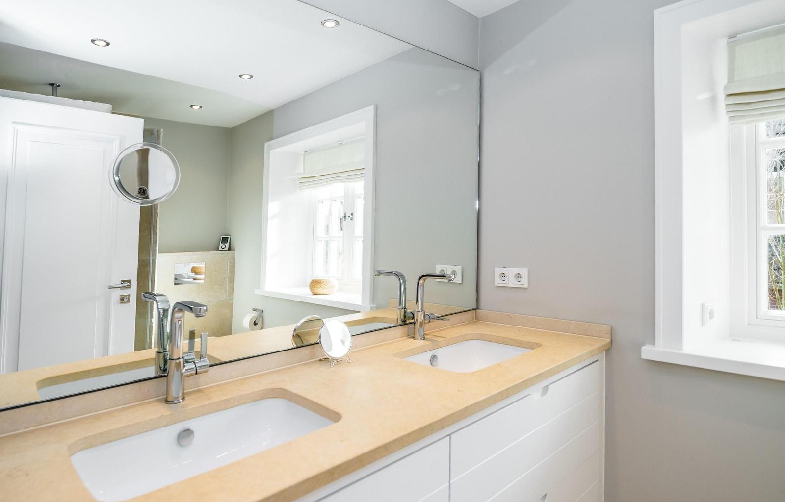 Bad mit Doppelwaschbecken, Spiegel und Fenster