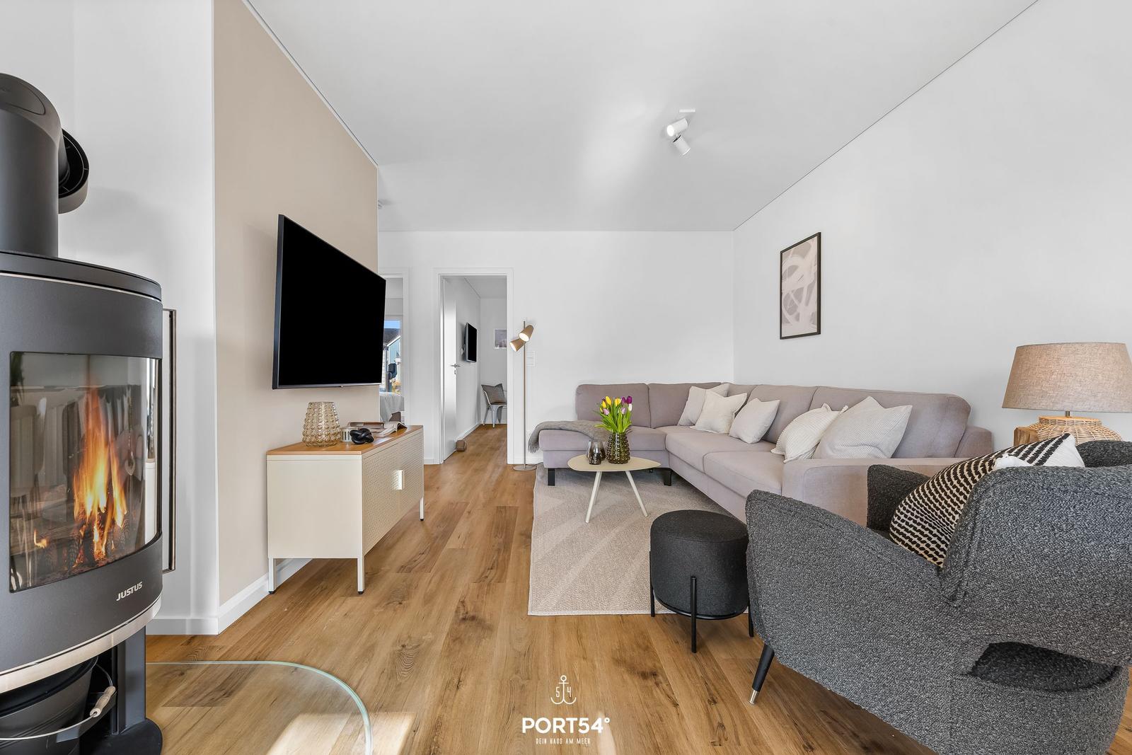 Wohnzimmer mit Sofa, Kamin und Fernseher.