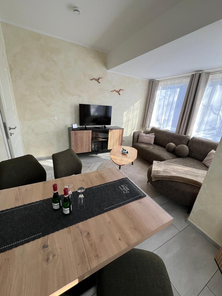 Wohn- und Essbereich mit Sofa, TV und Esstisch.