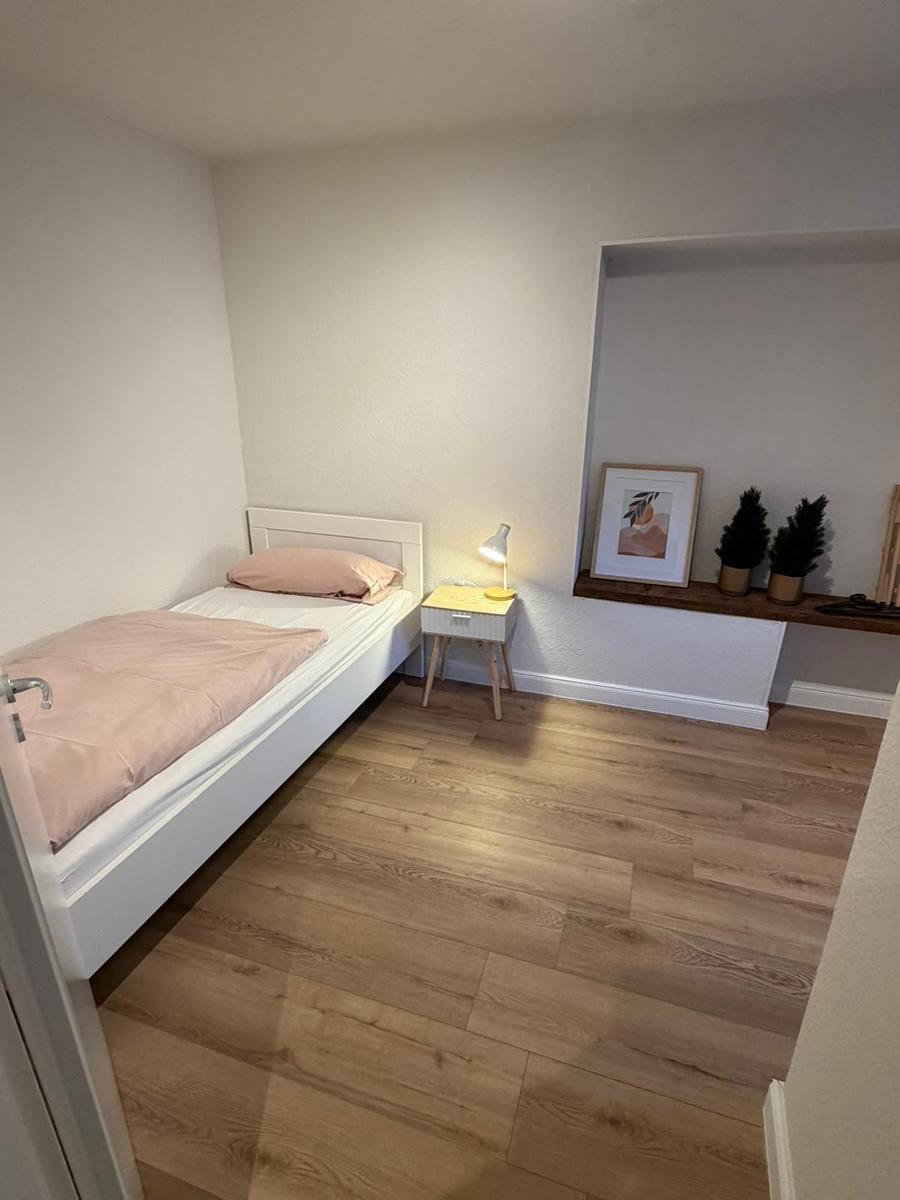 Ein Schlafzimmer mit einem Bett, Nachttisch und Holzboden.