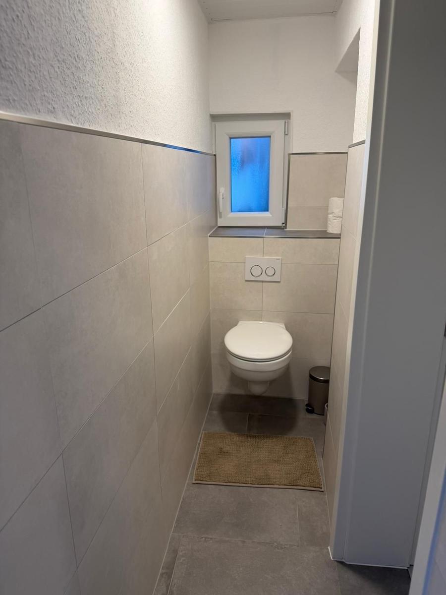 Flur mit Toilette und Fenster mit blauem Glas