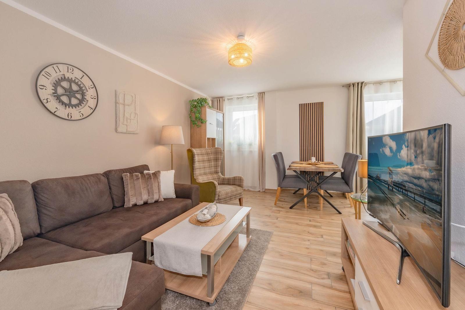 Wohn- und Essbereich mit Sofa, TV und Esstisch.