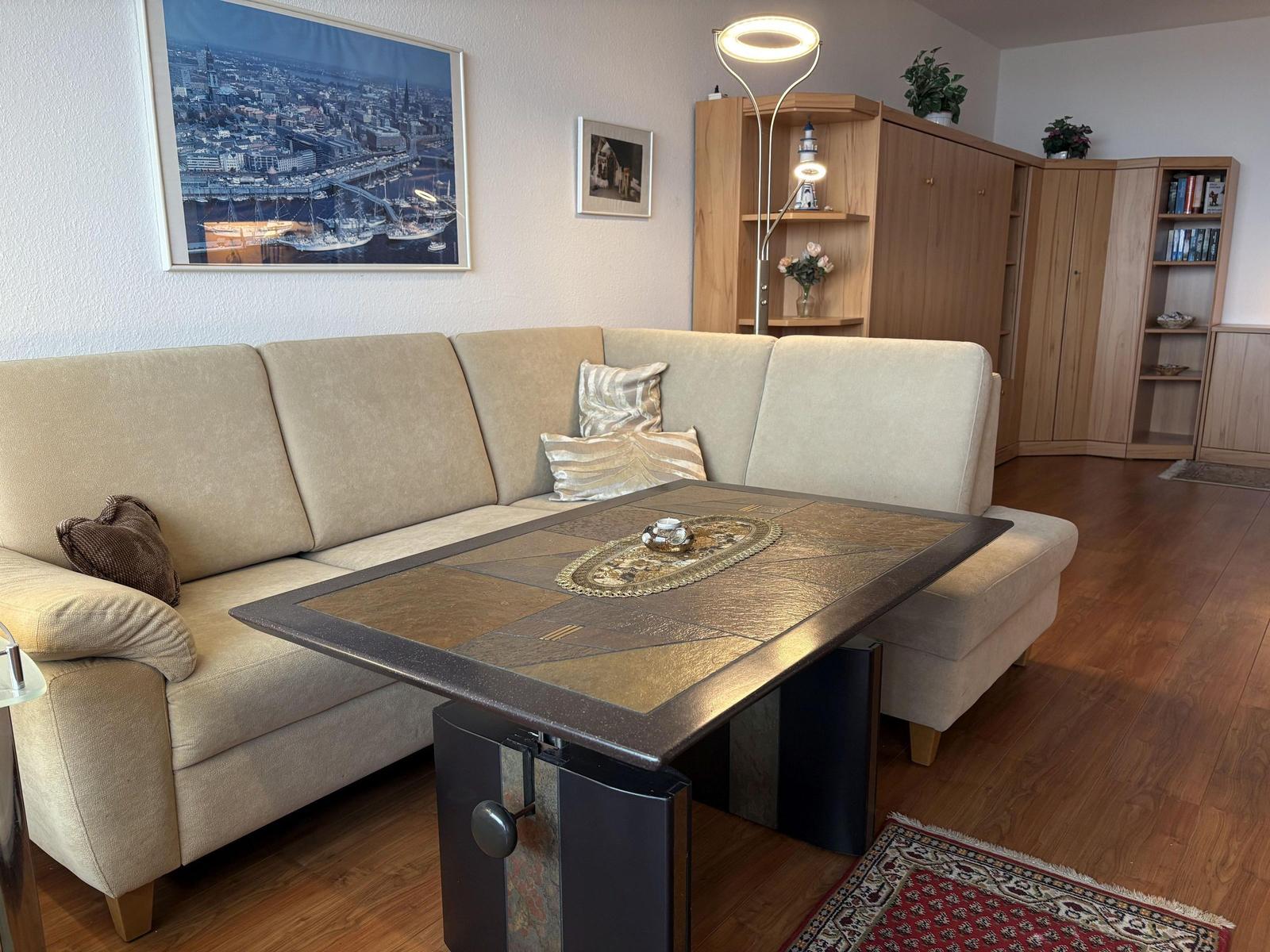 Wohnzimmer mit Sofa, Tisch und Holzmöbeln.