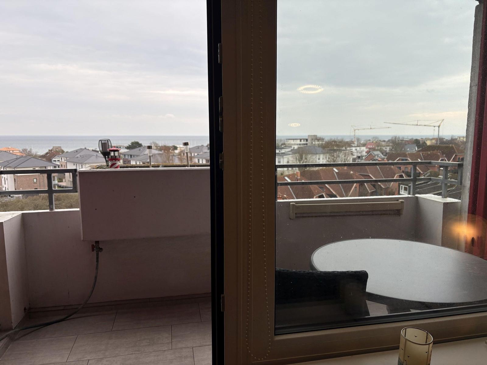 Balkon mit Tisch und Blick auf Meer und Stadt