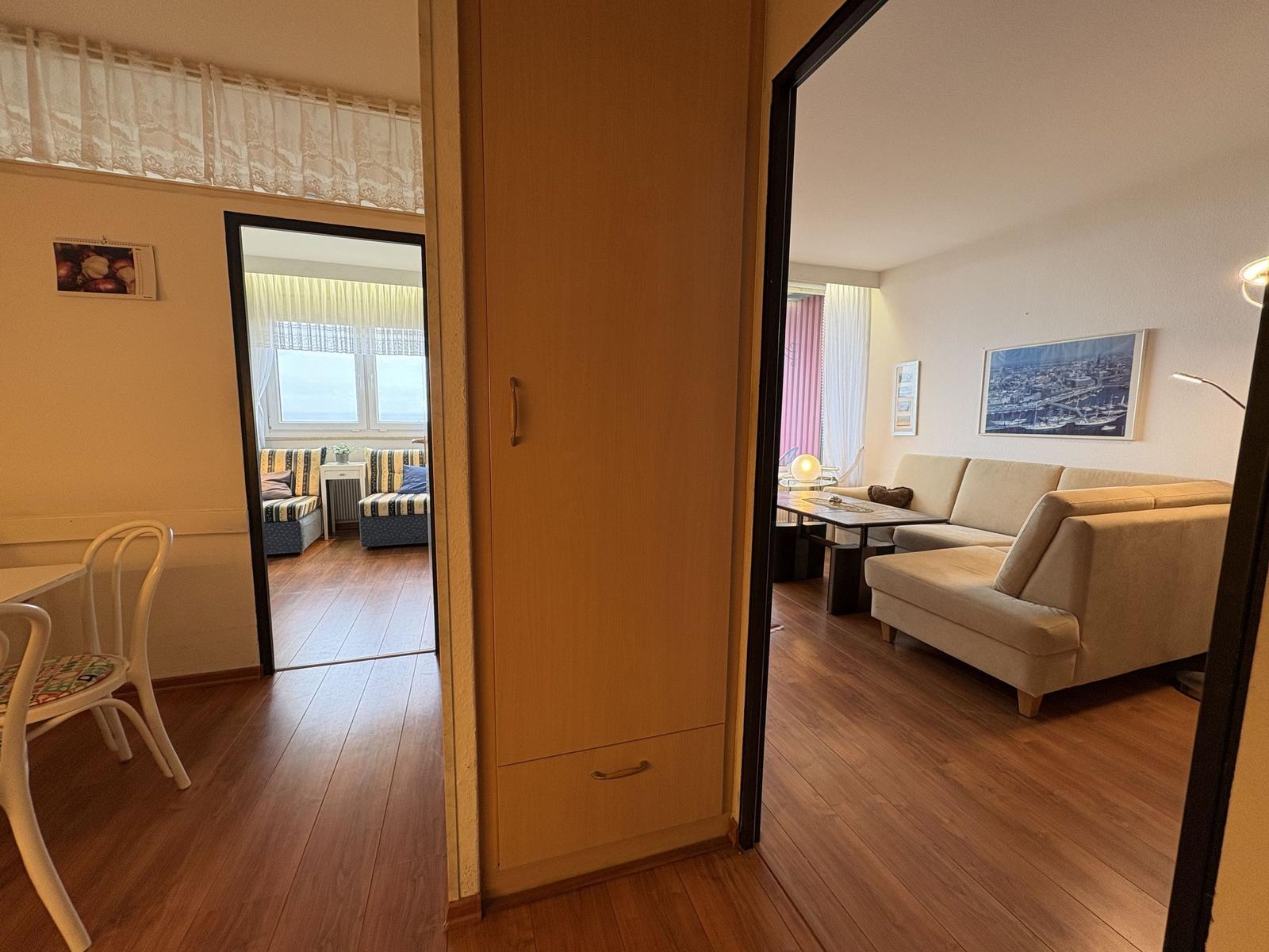 Wohnung mit Essbereich, Schlafzimmer und Wohnzimmer mit Sofa und Tisch.